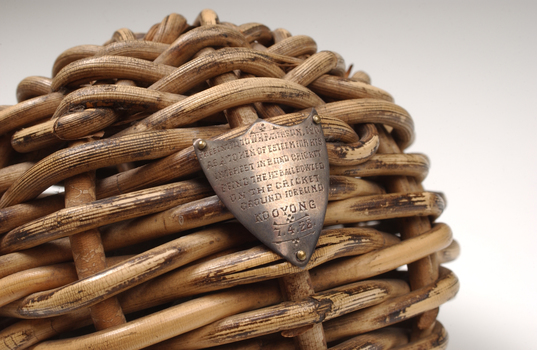 Braided wicker in ball shape with miniature metal shield attached