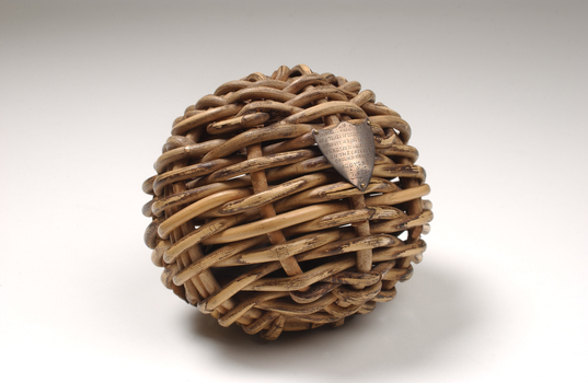 Braided wicker in ball shape with miniature metal shield attached