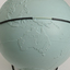 Light blue sphere with raised surfaces of various textures and braille writing