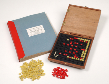 Braille book and wooden box containing yellow and red rubber markers