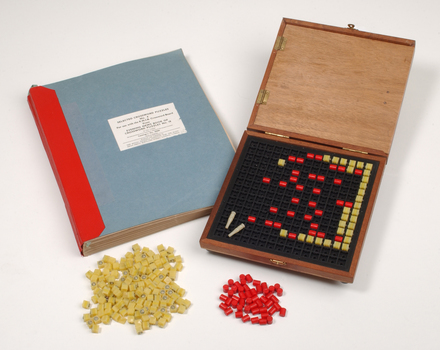 Braille book and wooden box containing yellow and red rubber markers