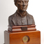 Bronze bust of Louis Braille on wooden mount.
