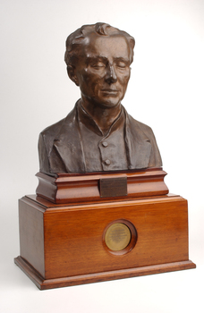 Bronze bust of Louis Braille on wooden mount.