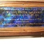 Brown wooden memorial tablet with inset of copper and photograph.
