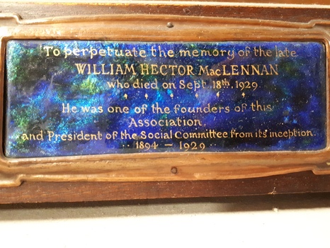 Brown wooden memorial tablet with inset of copper and photograph.