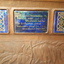 Brown wooden memorial tablet with inset of copper and photograph.