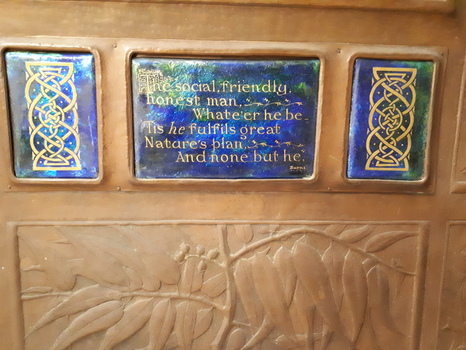 Brown wooden memorial tablet with inset of copper and photograph.