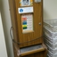 Chipboard rectangle with wooden veneer.  Metal covers for money slots and plastic covers over paper labels.