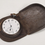 Brown case holding pocket watch with Braille markings
