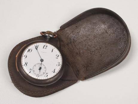 Brown case holding pocket watch with Braille markings