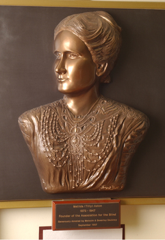 Mounted sculpture showing head and shoulders profile of Tilly Aston.