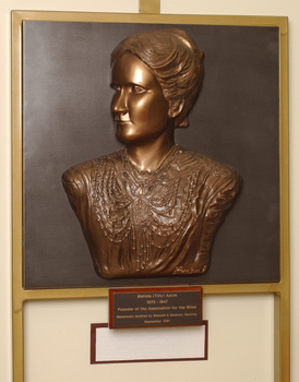 Mounted sculpture showing head and shoulders profile of Tilly Aston.