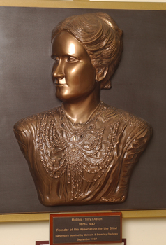 Mounted sculpture showing head and shoulders profile of Tilly Aston.