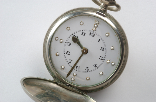 Opened watch with braille markers and numbers on watch face