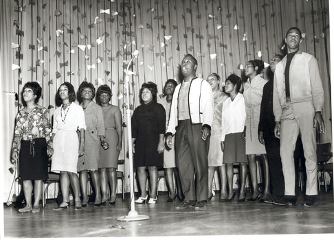 Twelve singers on stage performing