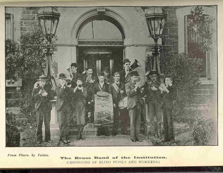 12 musicians holding their instruments ready to play outside the RVIB building