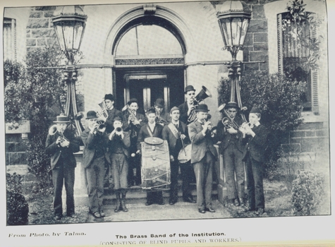 12 musicians holding their instruments ready to play outside the RVIB building