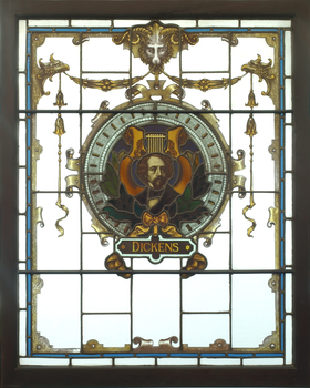 Three animals holding a shield featuring an image of Charles Dickens