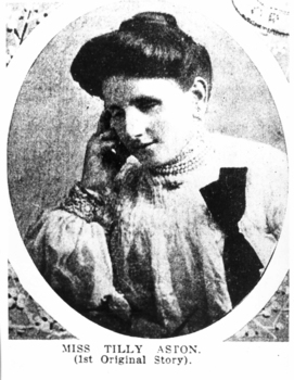 Woman wearing white dress with flounces and black bow, holds her hand up to her face