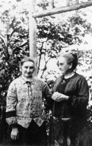 Two older woman standing in a garden