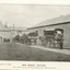 Man loading basket on to the back of one cart whilst two other carts are unloading raw materials at workshop