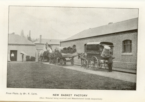 Man loading basket on to the back of one cart whilst two other carts are unloading raw materials at workshop
