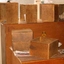 Wooden boxes inside Raleigh Street house with ashtray, drink bottle and bowl upon table