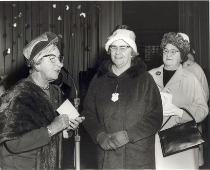 Mrs Tutton at the microphone with a line of woman approaching her