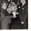 Mrs Tutton receiving flowers from a suited man