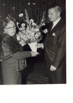 Mrs Tutton receiving flowers from a suited man