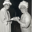 Mrs Tutton clasping the hands of another woman
