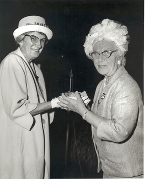 Mrs Tutton clasping the hands of another woman