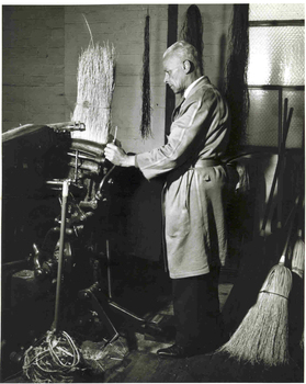 Man flattening millet on broom