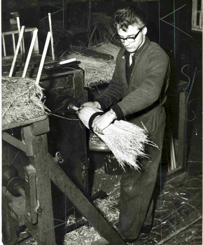 Man adjusting millet strands on broom