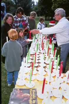 People buying candles at Carols by Candlelight