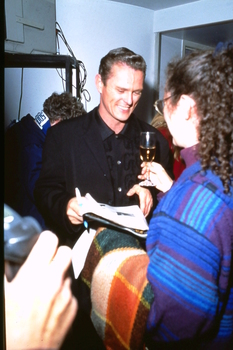 Male performer given a glass of wine backstage