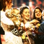 Rhonda Burchmore holding baby Lexie(?) Marina Prior and Silvie Palladino on stage at the end of Carols