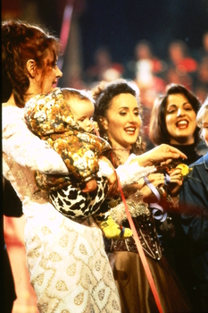 Rhonda Burchmore holding baby Lexie(?) Marina Prior and Silvie Palladino on stage at the end of Carols