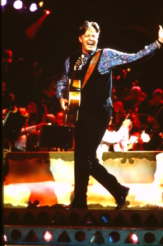 Tommy Emmanuel walking on stage waving to the crowd