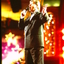 Denis Walter singing on stage at Carols