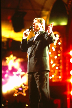 Denis Walter singing on stage at Carols