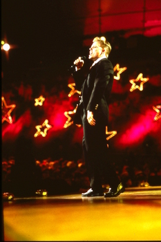 David Dixon singing on stage at Carols