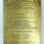Gold coloured plate with brown inscription