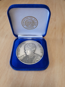 Silver coloured medallion in blue velvet box