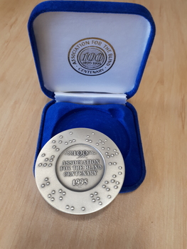 Silver coloured medallion in blue velvet box