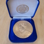 Gold coloured medallion in blue velvet box