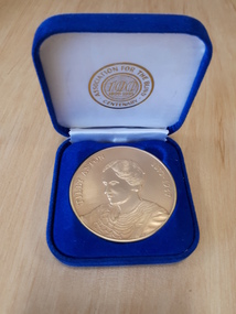 Gold coloured medallion in blue velvet box