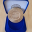 Gold coloured medallion in blue velvet box