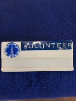 White plastic badge with RVIB logo in top left hand corner