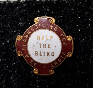 Red and white badge with gold edging